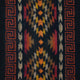 Colorful woven textile displays geometric patterns in red, orange, yellow, and beige centered within a dark background, bordered by red Greek key motifs on both sides.