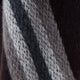 A textured, knitted fabric with diagonal stripes in shades of white, gray, and black. The fibers appear soft and fuzzy, creating a cozy and warm appearance.
