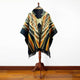 Shakai alpaca wool hooded poncho – a poncho with geometric tribal patterns in earthy colors is displayed on a wooden stand against a plain white wall and wooden floor