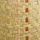 A close-up view of a woven basket, showing interlaced natural fibers with beige and light brown tones. It highlights the intricate weaving pattern without any surrounding elements.