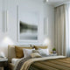 Atocha alpaca wool throw blanket – bed with patterned cushions and layered blankets is set in a neutral-toned bedroom. Two pendant lights hang from the ceiling, with abstract artwork and a side table nearby