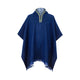 A blue poncho with a hood and decorative patterned trim hangs against a plain white background, featuring a fringed hemline at the bottom edge.