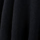 Achema llama wool hooded poncho – dark, textured fabric drapes gently, creating soft folds and shadows, suggesting a cozy, dense material. The background is uniform, emphasizing the fabric's texture and depth