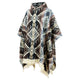 A poncho displays a geometric pattern in earthy tones, featuring fringed edges. The garment is draped and buttoned at the collar, set against a plain, white background.