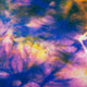 A vibrant abstract pattern featuring swirling colors of blue, pink, and yellow, resembling a tie-dye effect, with a textured, fabric-like surface suggesting dynamic movement and energy.