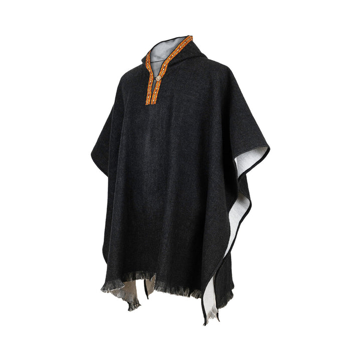 A dark poncho with an orange embroidered collar is displayed, featuring a loose drape and a fringed hem, against a plain white background.