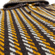 Hooded garment with alternating brown, yellow, and white horizontal stripes, featuring buttons down the front. It is shown in close-up, highlighting the woven pattern and texture.