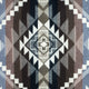 Geometric pattern with diamond and zigzag shapes interlocking in earthy tones of brown, beige, and black, creating a complex tapestry-like design. There is no text.