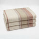 Zhumir baby alpaca wool blanket – a folded stack of three beige blankets with brown and gray stripes, neatly arranged against a plain white background
