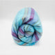 Tzacantza baby alpaca wool blanket – a woolen blanket, rolled tightly, features pastel stripes of blue, purple, and green, set against a plain, light gray background