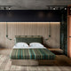 Jambue baby alpaca wool blanket – bed sits centered with striped bedding and two pillows against a wood-paneled wall. Ceiling track lights illuminate, with minimalistic green wall fixtures on either side. Wooden floor completes the modern bedroom