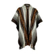 A woven poncho with geometric patterns in brown, white, and black, featuring a button closure at the neck. The design includes stripes and diamond motifs, with fringed edges.