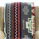 A decorative blanket featuring geometric patterns and colorful stripes draped over an ornate beige chair, adding a vibrant touch to the subdued setting.