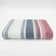 Pindo baby alpaca wool blanket – a neatly folded, multicolored striped fabric laying on a smooth, white surface. The stripes include white, blue, grey, and red shades, creating a pattern across the fabric